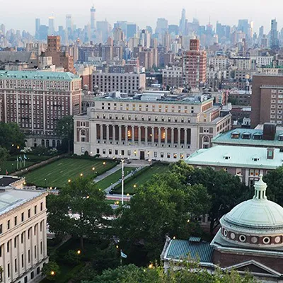 Aerial view of the Columbia University Morningside campus with the New York City skyline in the background